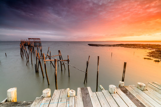 Fiery sky at dawn on the Palafito Pier in the Carrasqueira Natural Reserve of Sado River Alcacer do Sal Setubal Portugal Europe