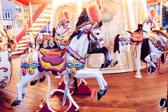 Old French carousel in a holiday park. Merry-go-round with horses