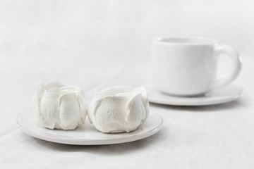 Sweet white meringue and cup of coffee. Delicate delicious dessert. Light dessert. Selective focus.