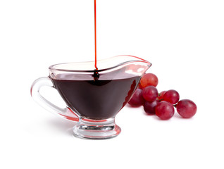 Balsamic vinegar in bowl with grape. Isolated on white background