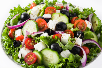 Fresh Greek salad in Plate with black olive,tomato,feta cheese, cucumber and onion isolated on...