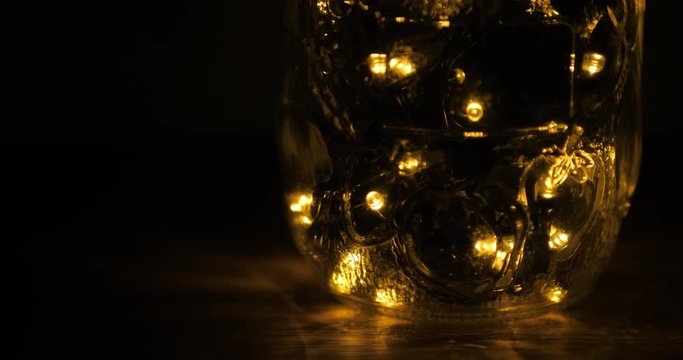 Glowing led lights inside a transparent jar in the darkness