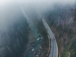 aerial view of road in mountains. fog covered the forest