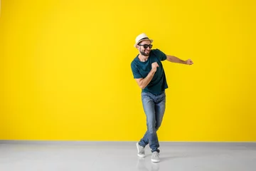 Poster Handsome young man dancing near color wall © Pixel-Shot