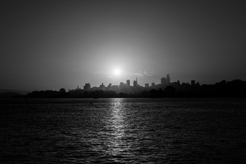 Black and white of the sunrise sun rising over downtown San Francisco