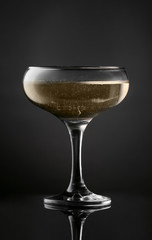 Glass of tasty champagne on dark background