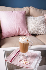 Glass cup of tasty frappe coffee with marshmallow on table