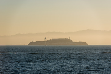 Fototapeta premium Island and Alcatraz prison at sunrise from Fort Point, San Francisco