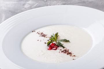 Semolina porridge with grated chocolate and pomegranate in plate over grey background. Healthy breakfast ingredients. Clean eating, vegan food concept