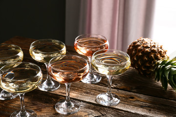Glasses of champagne and pineapple on wooden table