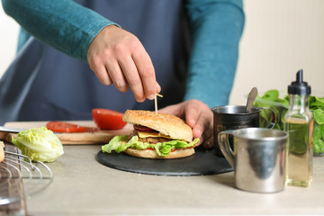 Male chef preparing burger in kitchen