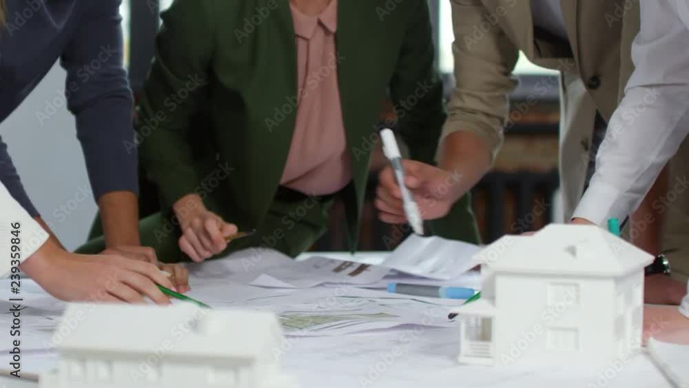 Aufkleber close-up of hands of multiethnic architects pointing with pencils at blueprints and discussing proje