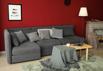 Stylish interior of room with comfortable big sofa