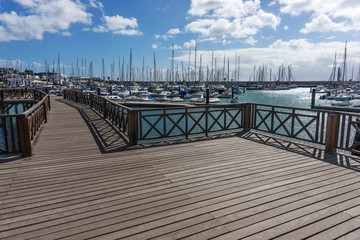Obraz premium Wooden bridge at the boat harbor of Marina Rubicon in Playa Blanca. Lanzarote. Canary Island. Spain