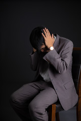Emotion of depressed businessman having something in mind to worry on head. failure of business concept isolated on dark background.