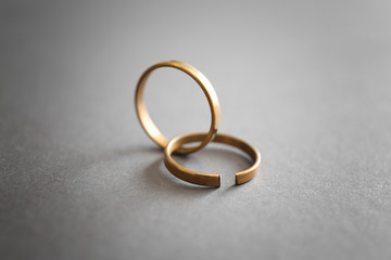 Whole and broken rings on grey background. Concept of divorce