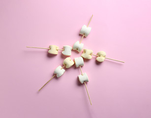 Sticks with tasty marshmallow on color background