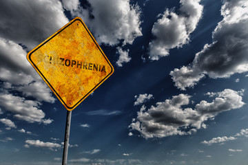 Dark blue cloudy sky and yellow faded road sign