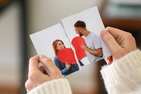 Woman tearing up photo of happy couple, closeup. Concept of divorce