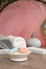 Fototapeta na wymiar Towels and soap bars on table in bathroom