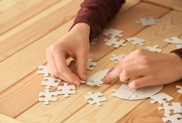 Obraz premium Woman assembling puzzle on table
