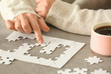 Woman assembling puzzle on table