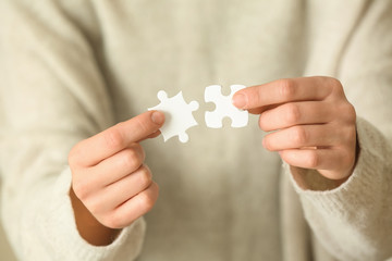 Woman holding pieces of puzzle, closeup