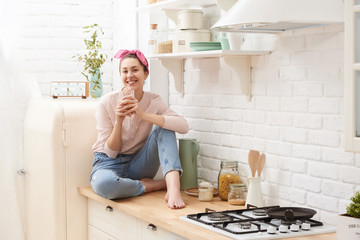 Portrait of beautiful young woman having breakfast in the kitchen