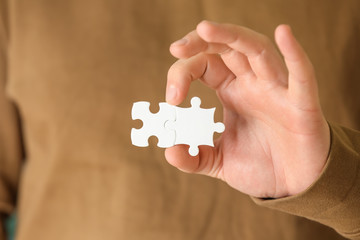 Man holding pieces of puzzle, closeup