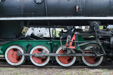 Old train and locomotive wheels. Railroad tracks stretches and green grass and trees. Railway road environment background.