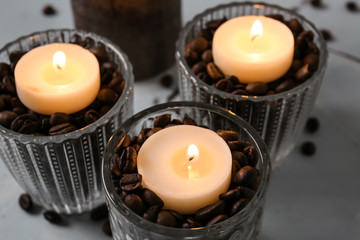 Burning candles in holders on table, closeup