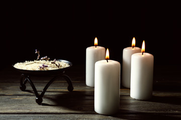 Beautiful spa composition with burning candles and sea salt on wooden table