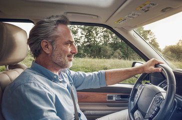 Side view of mature man driving car