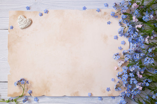 Forget-me-not flowers and greeting paper, letter on wooden background