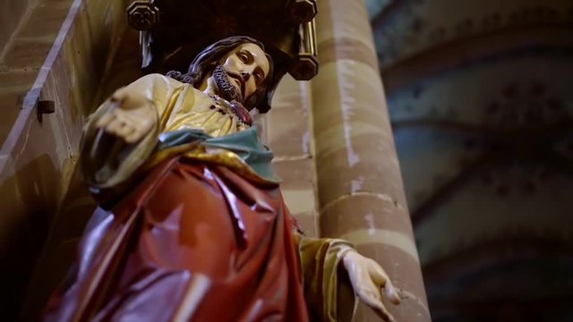 Below shot of a statue of a Christ in a catholic church, ancient monument indoor.