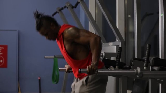 African american man push ups in gym on parallel bars