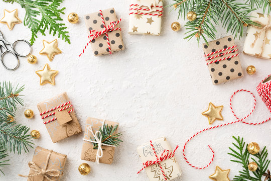 Christmas gift boxes, decorations, bakers twine & spruce on white background. Wrapped gifts, Cristmas preparation. Copy space.