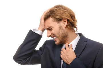 Young businessman suffering from headache on white background
