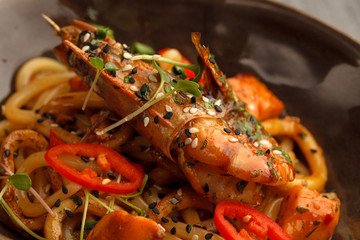 Stir fry with udon noodles, shrimps (prawns) and vegetables. Asian healthy food, meal