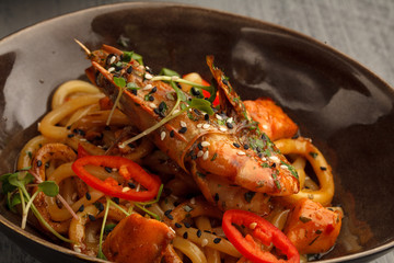 Stir fry with udon noodles, shrimps (prawns) and vegetables. Asian healthy food, meal