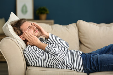 Young man suffering from headache at home