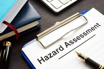 Hazard assessment form with clipboard on a desk. - obrazy, fototapety, plakaty
