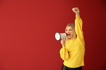 Emotional young woman with megaphone on color background
