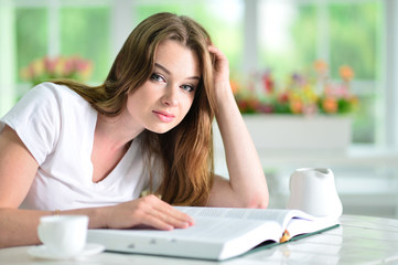 Close up portrait of beautiful young woman sitting at table