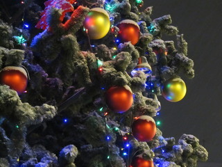 Night snapshot. Elegant Christmas tree decorated with Christmas toys, balls and garland