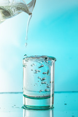 Pure water is poured into a glass beaker.