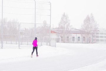 Runner girl in winter, sports in bad weather