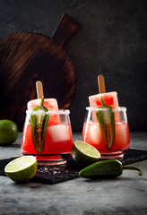 Spicy watermelon popsicle margarita cocktail with jalapeno and lime. Mexican alcoholic drink for Cinco de mayo party
