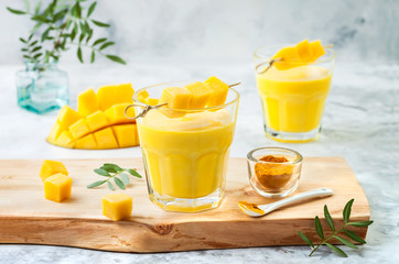 Mango Lassi, yogurt or smoothie with turmeric. Healthy probiotic Indian cold summer drink
