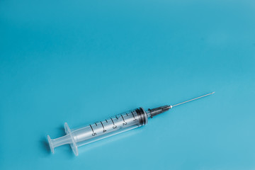 empty medical syringe on blue background, healing concept